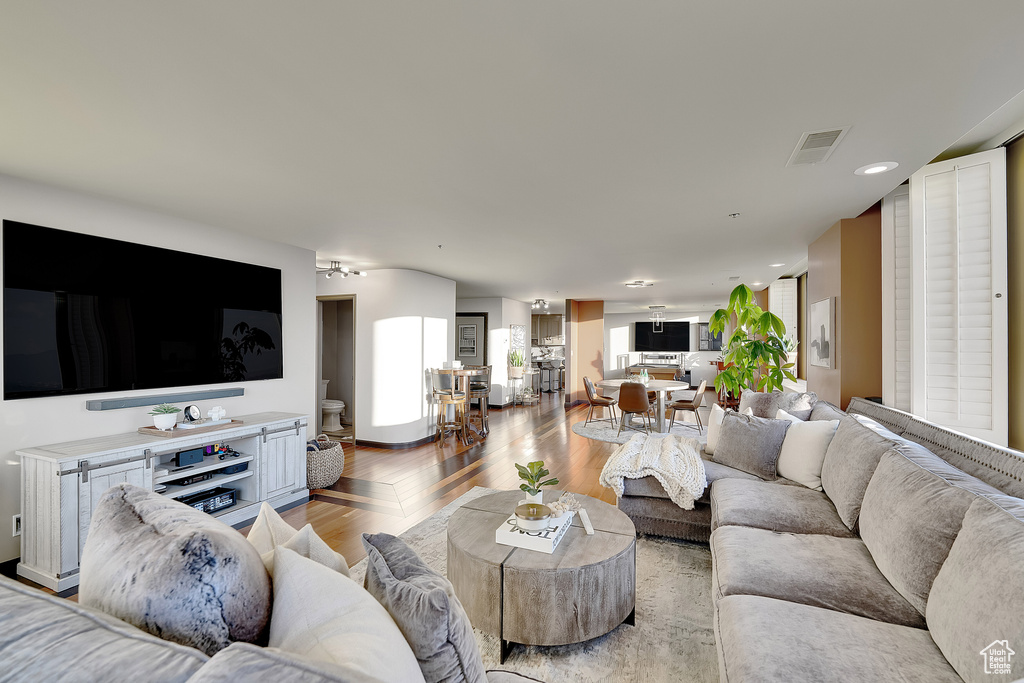 Living area with light wood-type flooring and recessed lighting