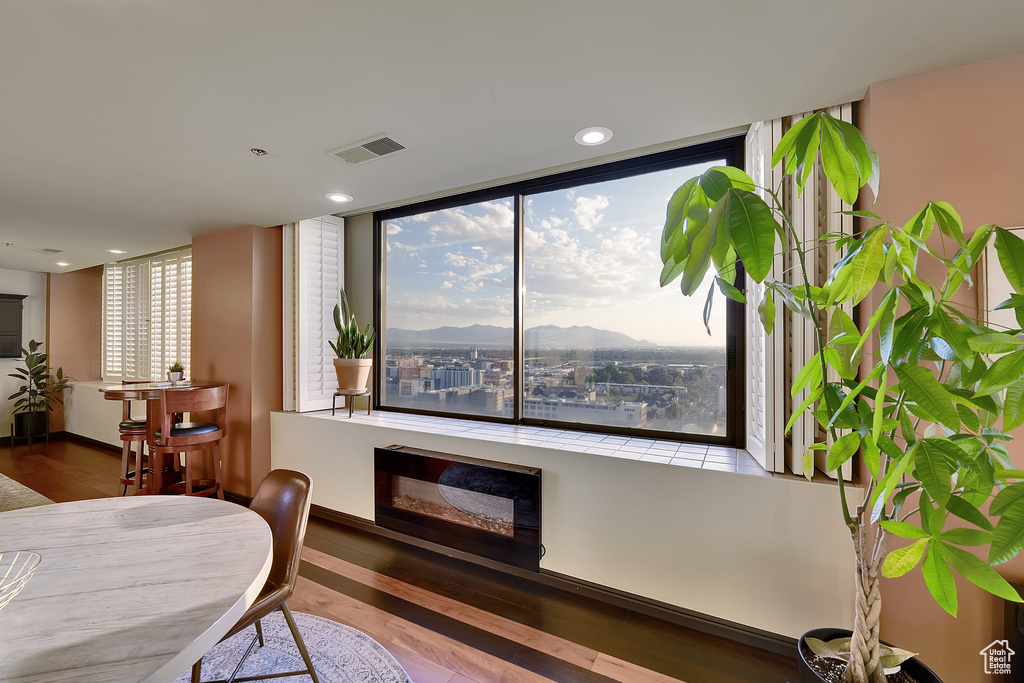 Dining room with a fireplace, wood finished floors, healthy amount of natural light, a mountain view, and recessed lighting