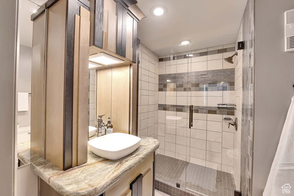 Full bath with a shower stall, vanity, and recessed lighting
