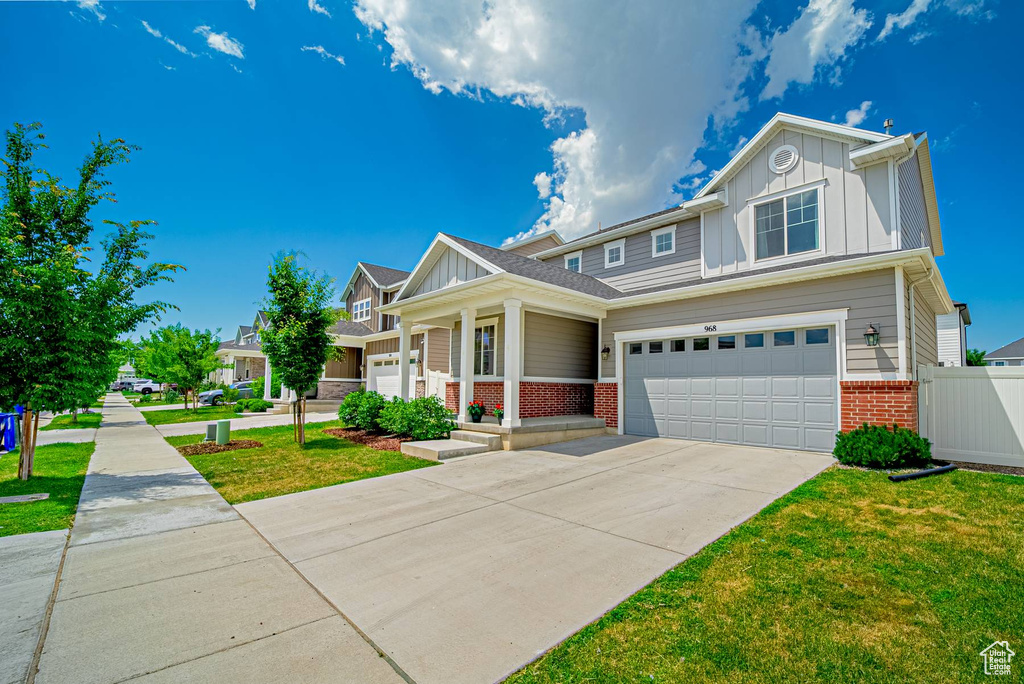 Craftsman house with board and batten siding, brick siding, driveway, and a garage