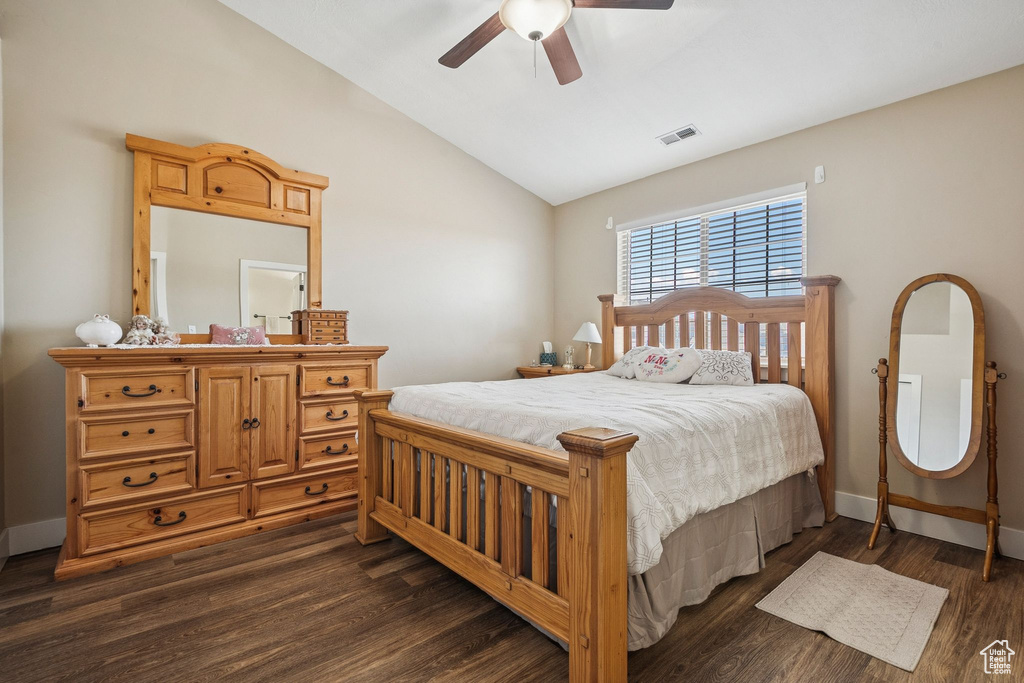Bedroom with vaulted ceiling, dark wood-style flooring, and a ceiling fan
