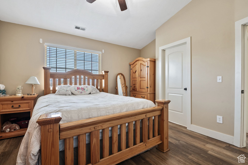 Bedroom with vaulted ceiling, dark wood-type flooring, and ceiling fan