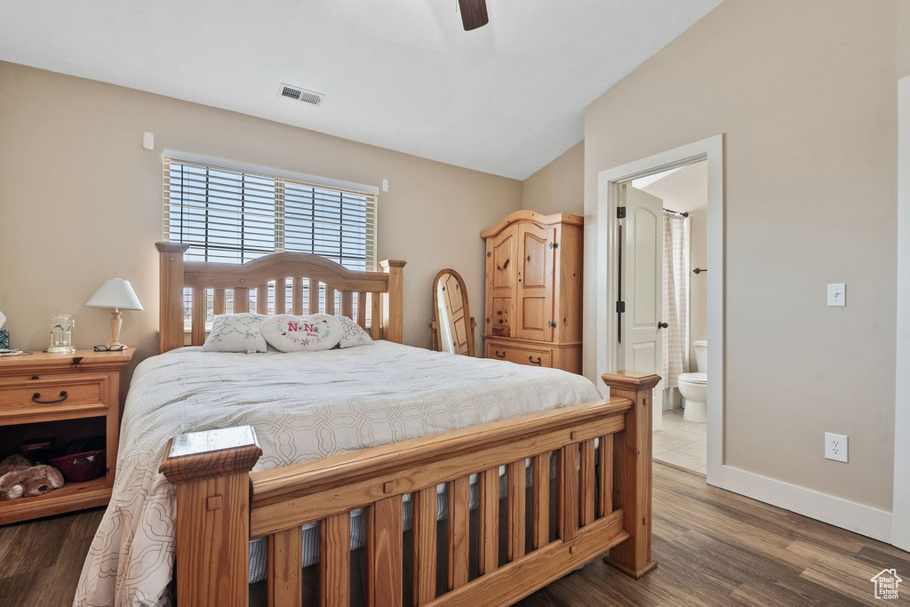 Bedroom with lofted ceiling, ensuite bathroom, wood finished floors, and a ceiling fan