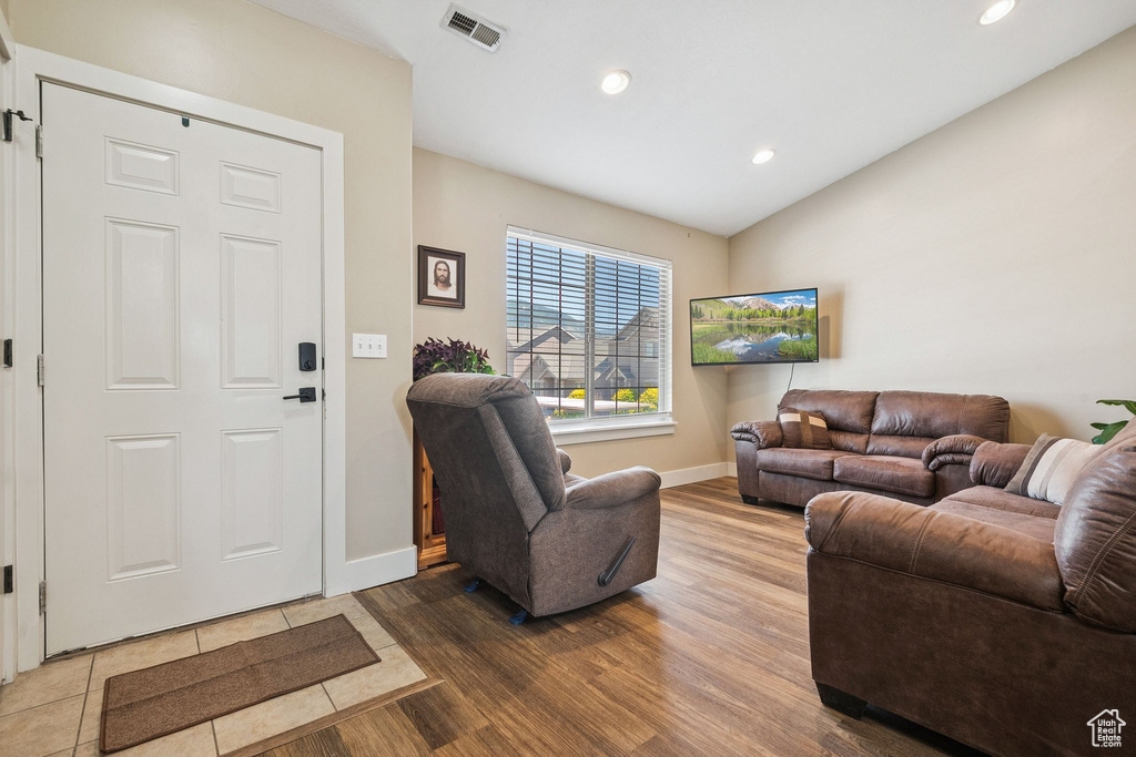 Living room featuring wood finished floors, recessed lighting, and lofted ceiling