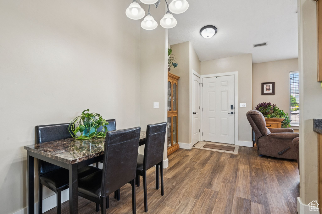 Dining space featuring wood finished floors and a chandelier
