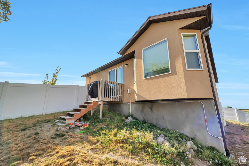 Rear view of house with stairway and stucco siding