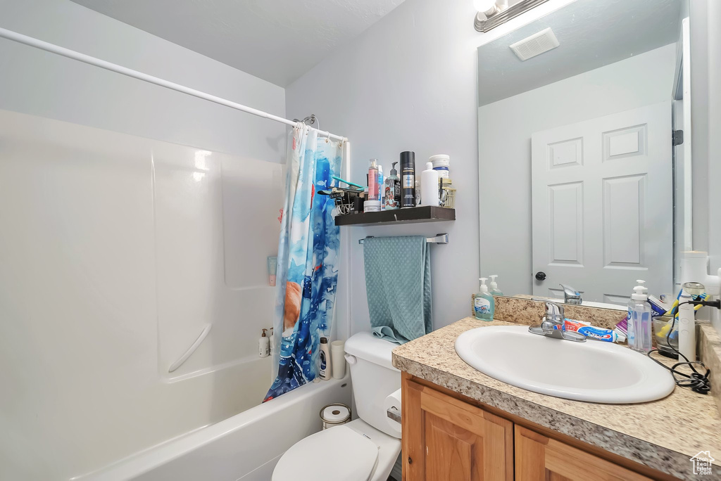 Bathroom with shower / bath combination with curtain and vanity