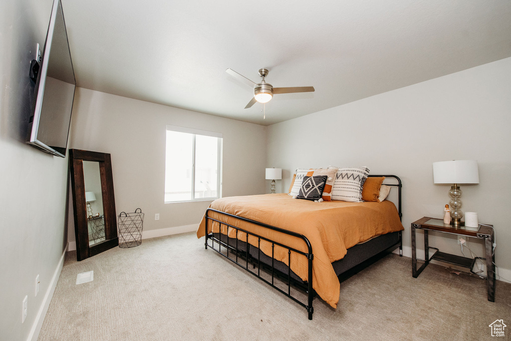 Bedroom with light colored carpet and ceiling fan