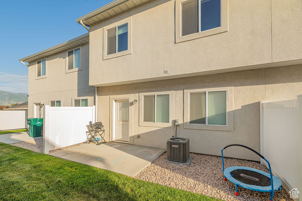 Back of property with stucco siding, a patio, and a mountain view