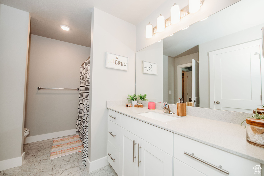 Full bathroom featuring vanity, recessed lighting, and marble look tile flooring