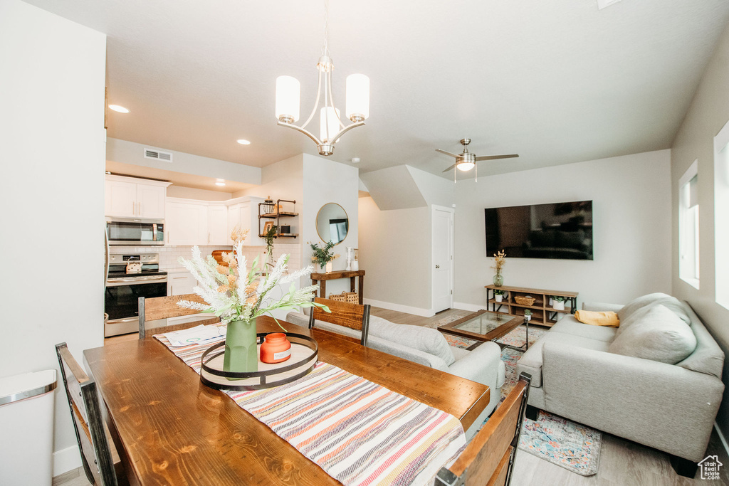 Dining area with a chandelier, light wood-style flooring, recessed lighting, and ceiling fan