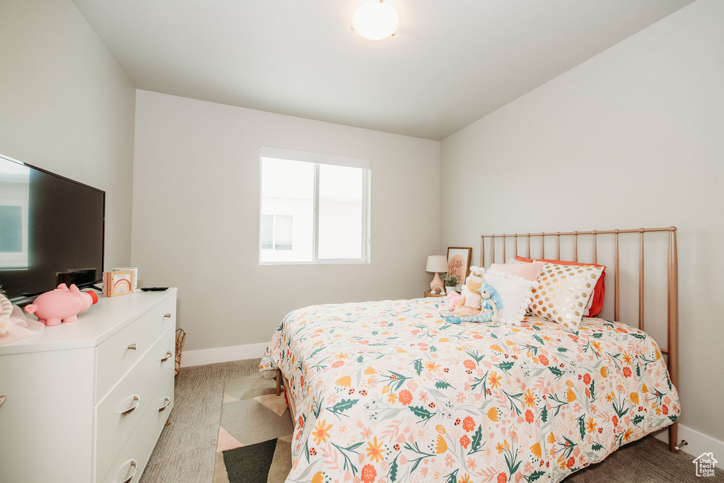 Bedroom featuring carpet and baseboards