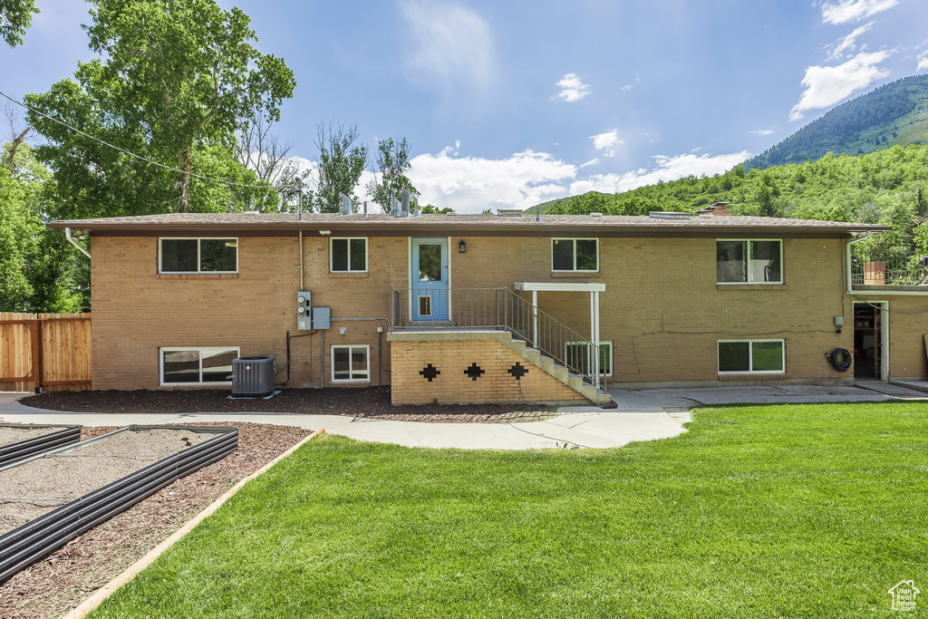 Back of property featuring a mountain view, brick siding, and a patio