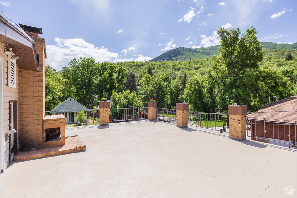 View of patio / terrace featuring a mountain view, a fireplace, and a forest view