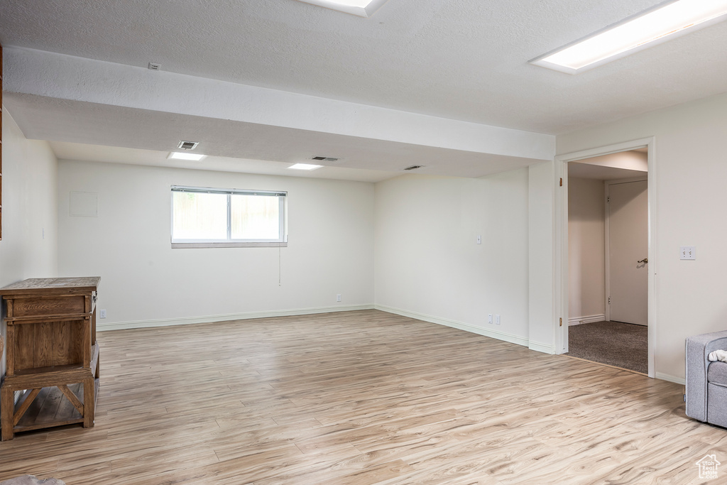 Basement with light wood-style flooring