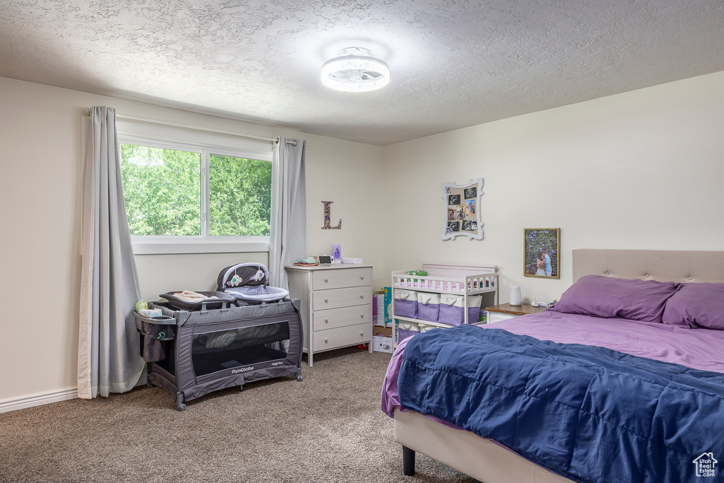 Bedroom featuring a textured ceiling and carpet