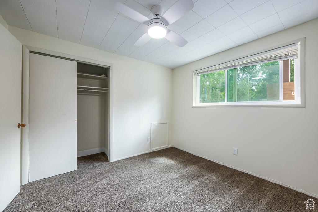 Unfurnished bedroom featuring carpet, a closet, and ceiling fan