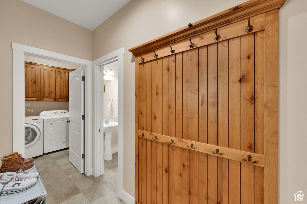 Laundry area featuring independent washer and dryer and cabinet space