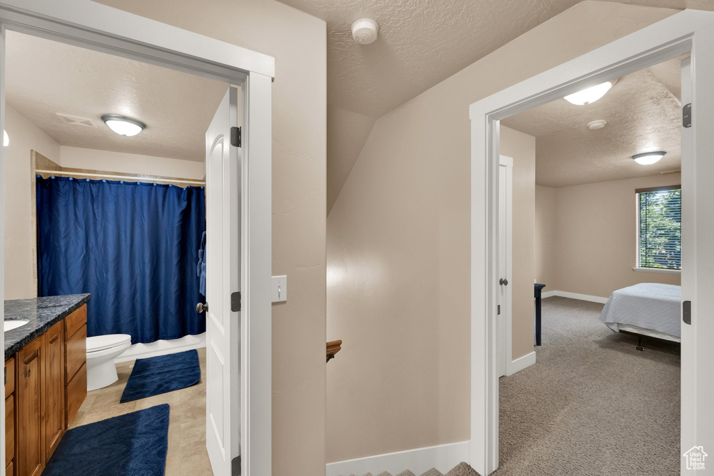 Full bathroom featuring a textured ceiling and vanity