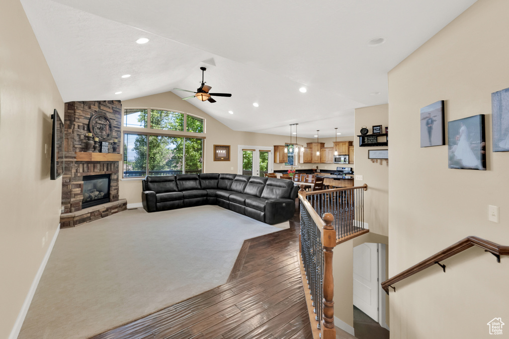 Living room with a fireplace, a ceiling fan, lofted ceiling, recessed lighting, and carpet floors