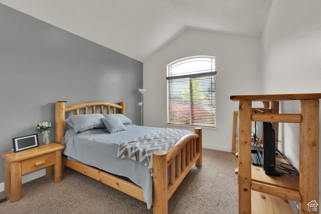Bedroom with lofted ceiling and carpet