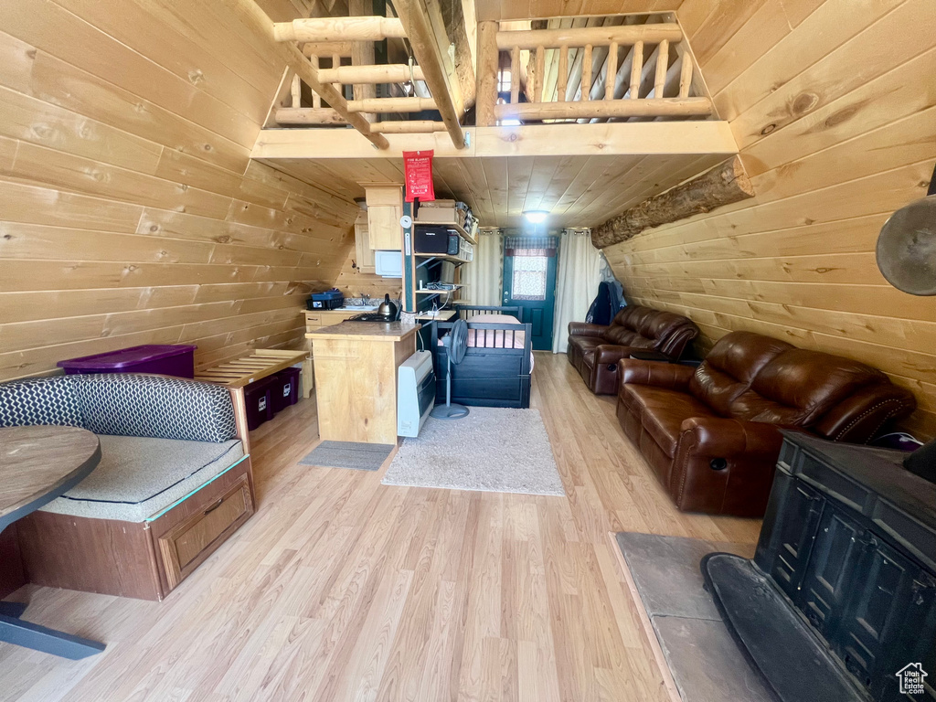 Living room with wood walls, light wood-style floors, wood ceiling, and vaulted ceiling