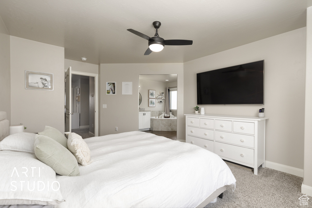 Bedroom featuring ensuite bathroom, ceiling fan, and light carpet