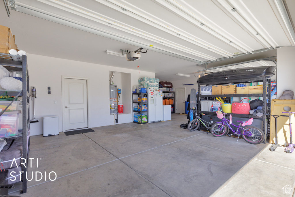 Garage with a garage door opener and strapped water heater