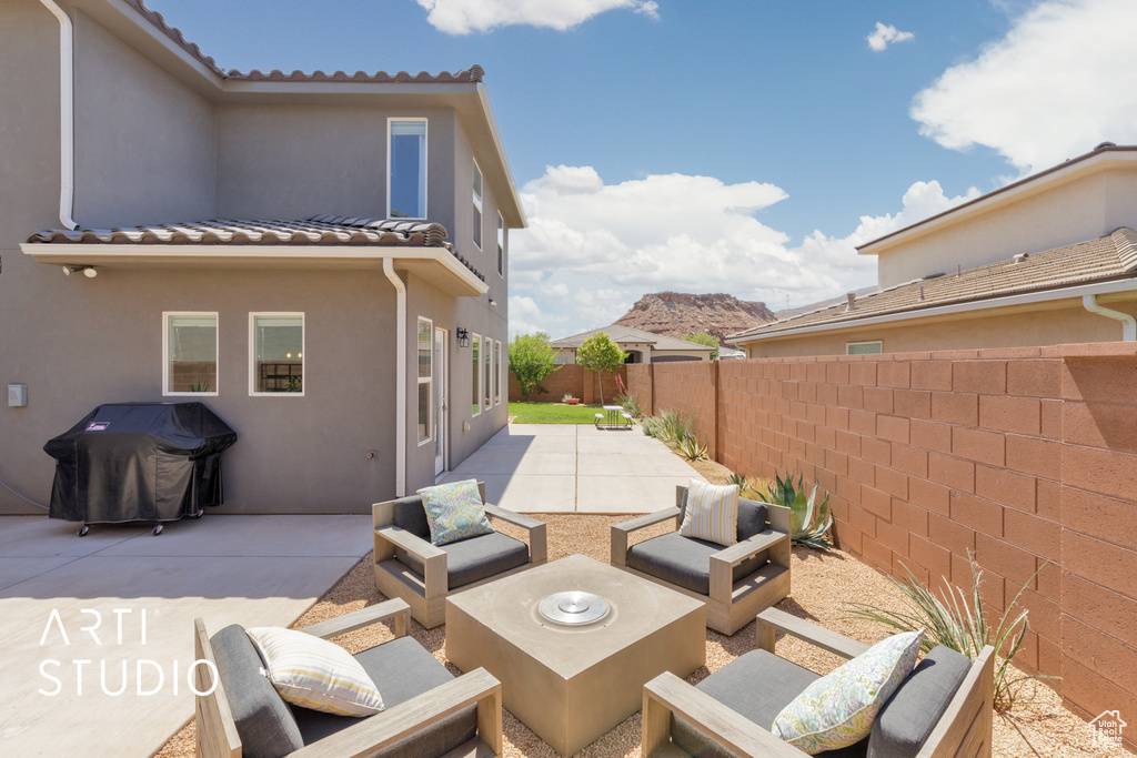 Fenced backyard with a grill, a patio area, and an outdoor hangout area