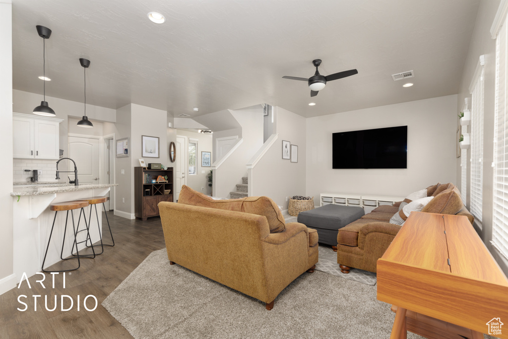 Living room with a ceiling fan, stairway, wood finished floors, and recessed lighting