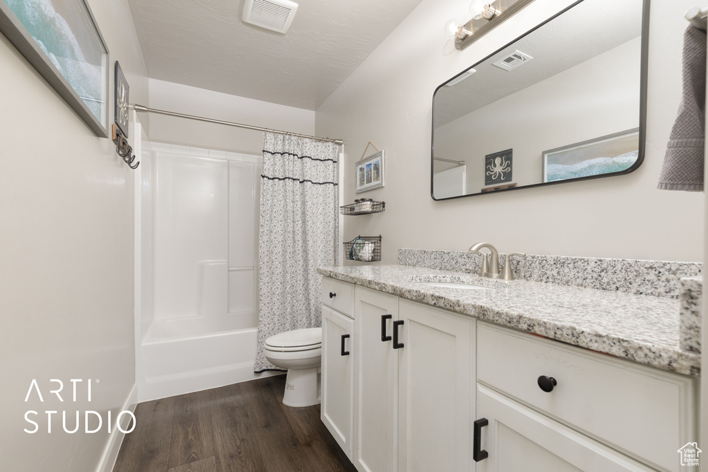 Full bathroom featuring wood finished floors, vanity, and shower / bathtub combination with curtain