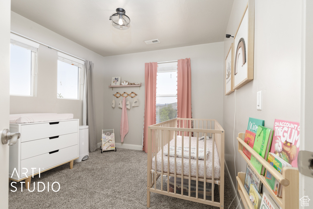Carpeted bedroom with a nursery area and baseboards