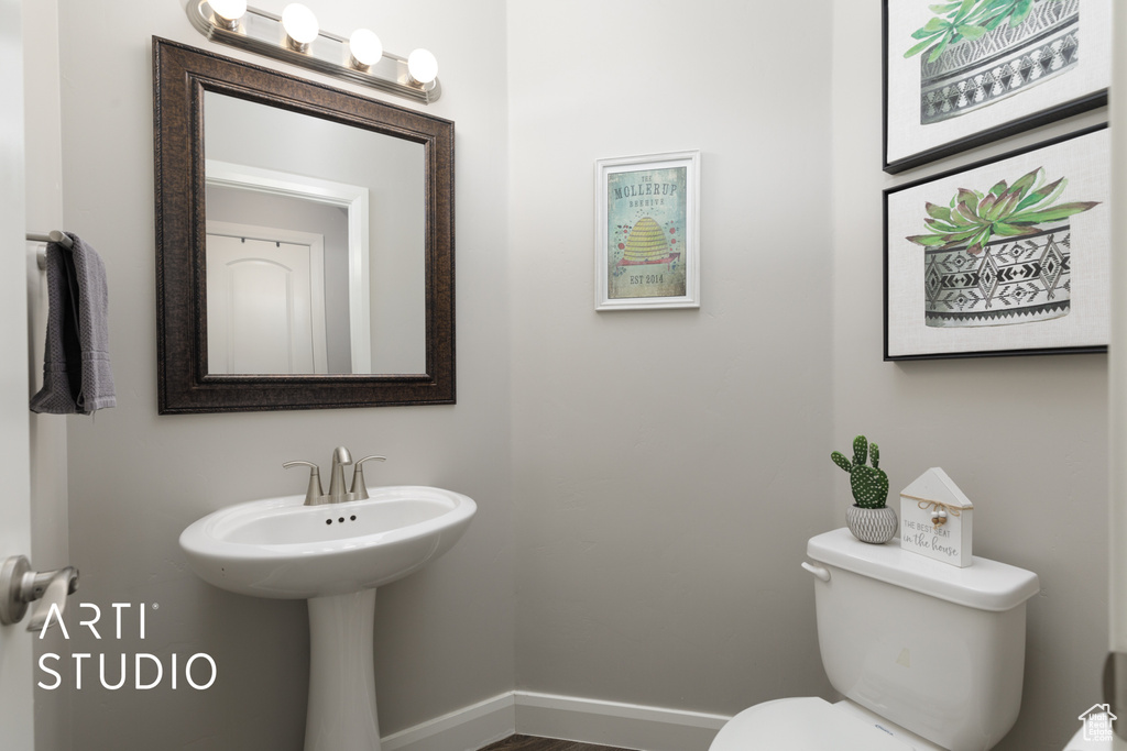 Half bath featuring toilet and baseboards