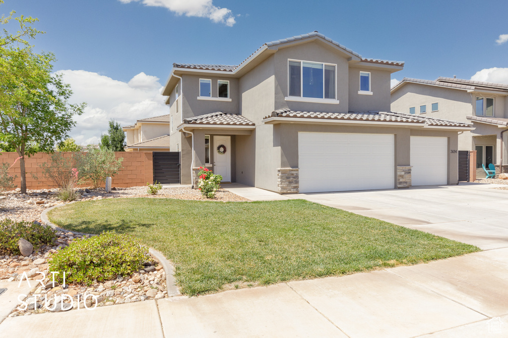 Mediterranean / spanish house with a tiled roof, a garage, concrete driveway, stucco siding, and stone siding