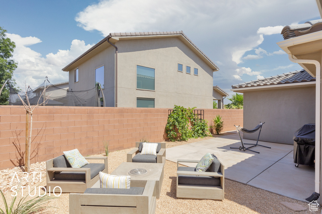 Fenced backyard with a patio area, an outdoor hangout area, and grilling area