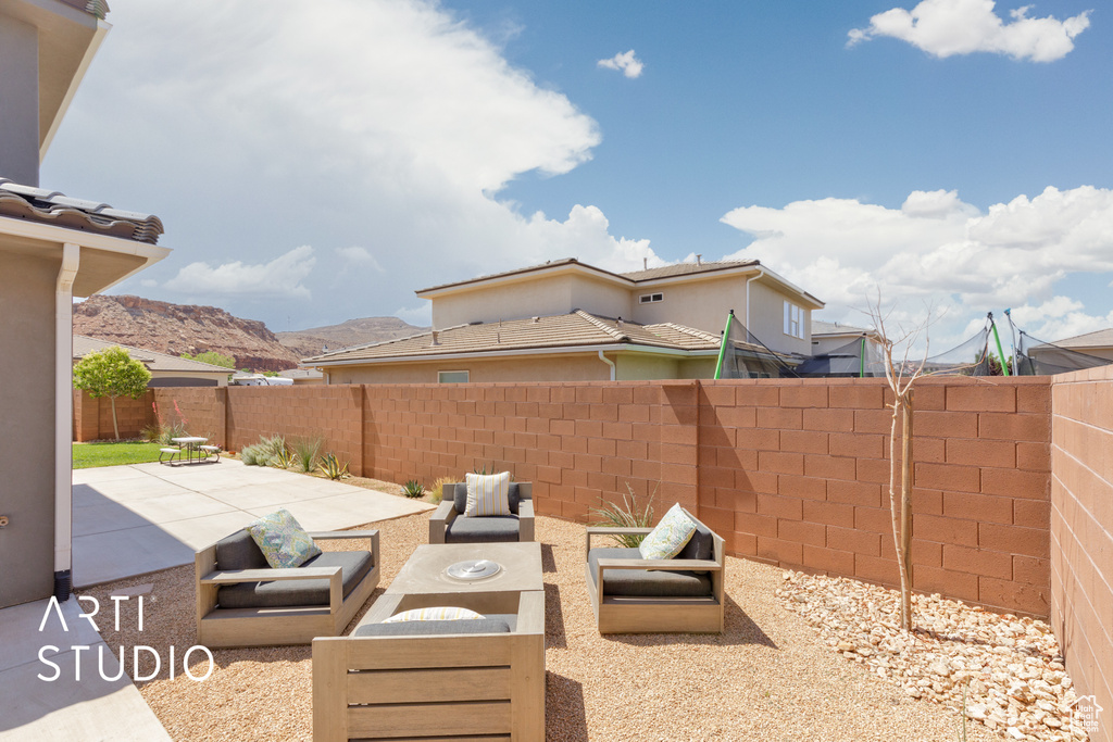 Fenced backyard featuring a patio and an outdoor hangout area