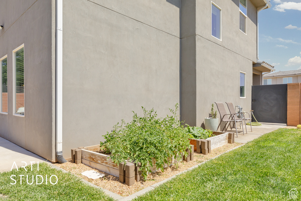 View of side of home featuring a vegetable garden and stucco siding