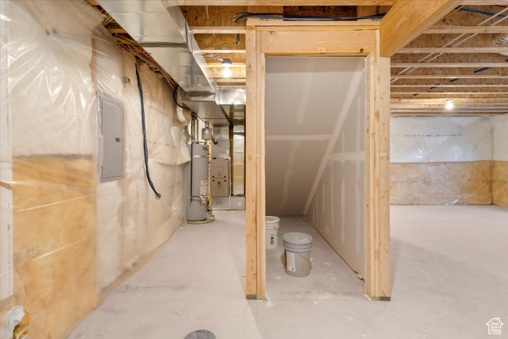 Unfinished below grade area featuring gas water heater and electric panel