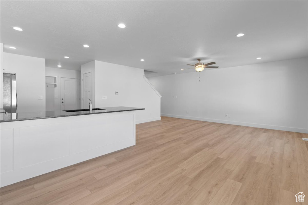 Unfurnished living room featuring a ceiling fan, recessed lighting, and light wood-style floors
