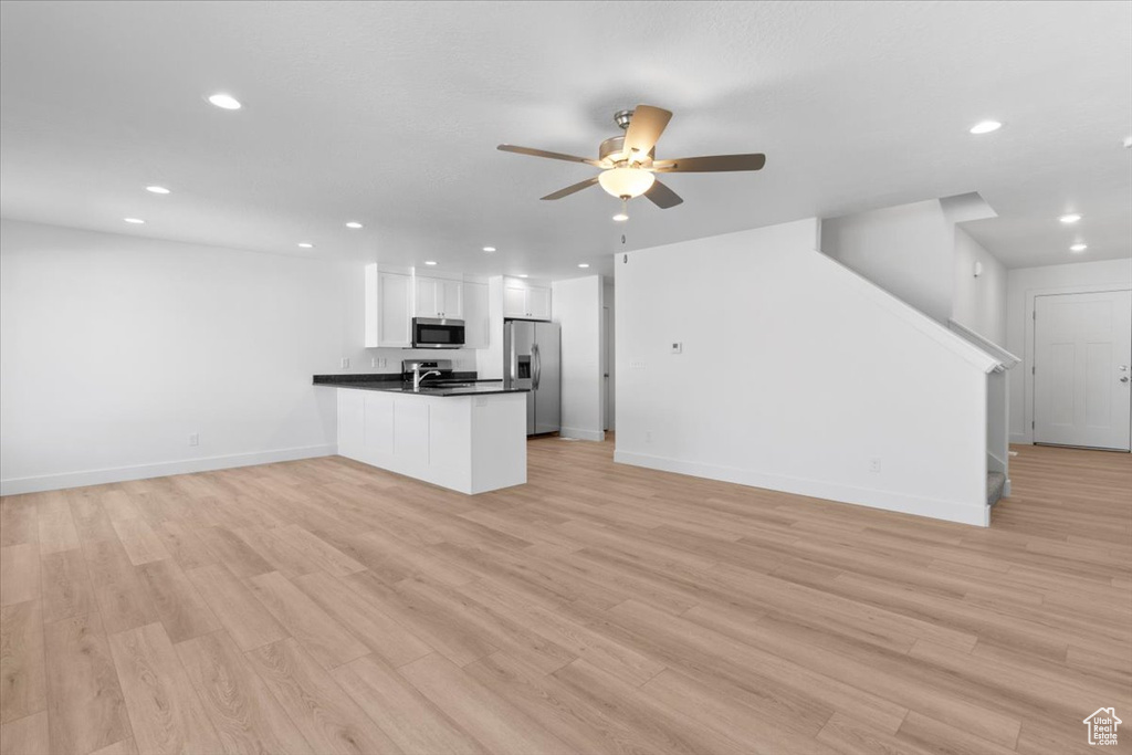 Unfurnished living room featuring stairway, ceiling fan, recessed lighting, and light wood finished floors