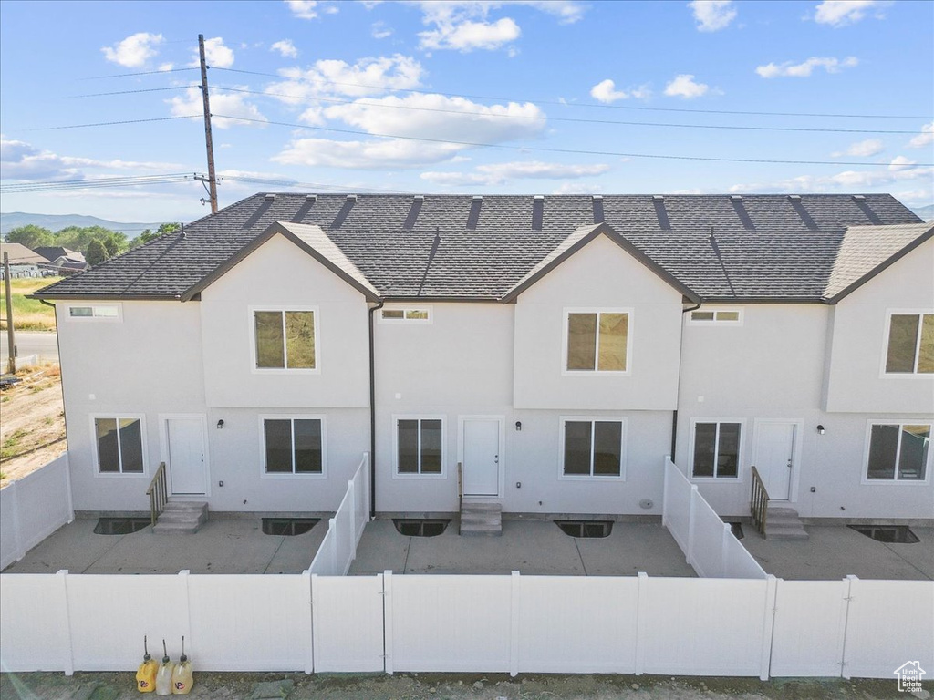 Back of house featuring entry steps, a fenced backyard, and stucco siding