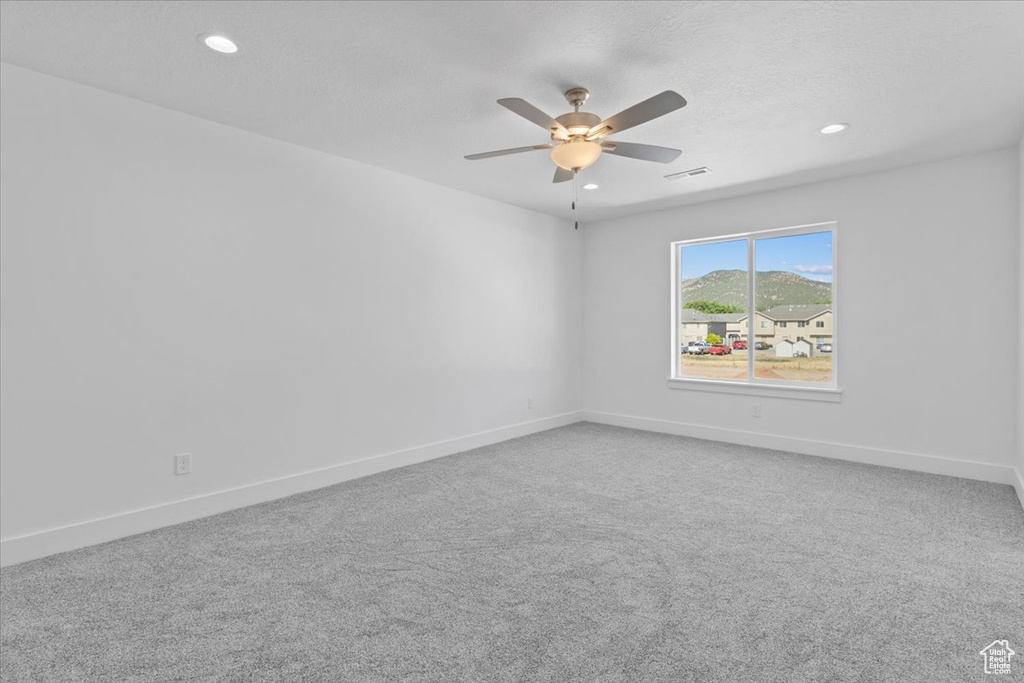 Carpeted spare room featuring ceiling fan and recessed lighting