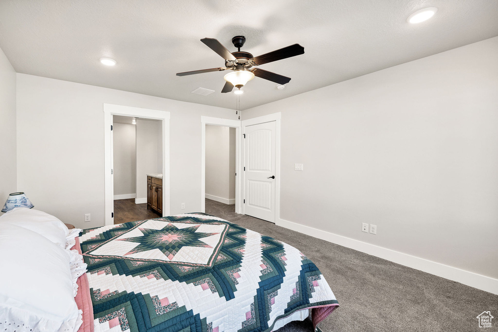 Bedroom with dark carpet, recessed lighting, ceiling fan, and ensuite bathroom