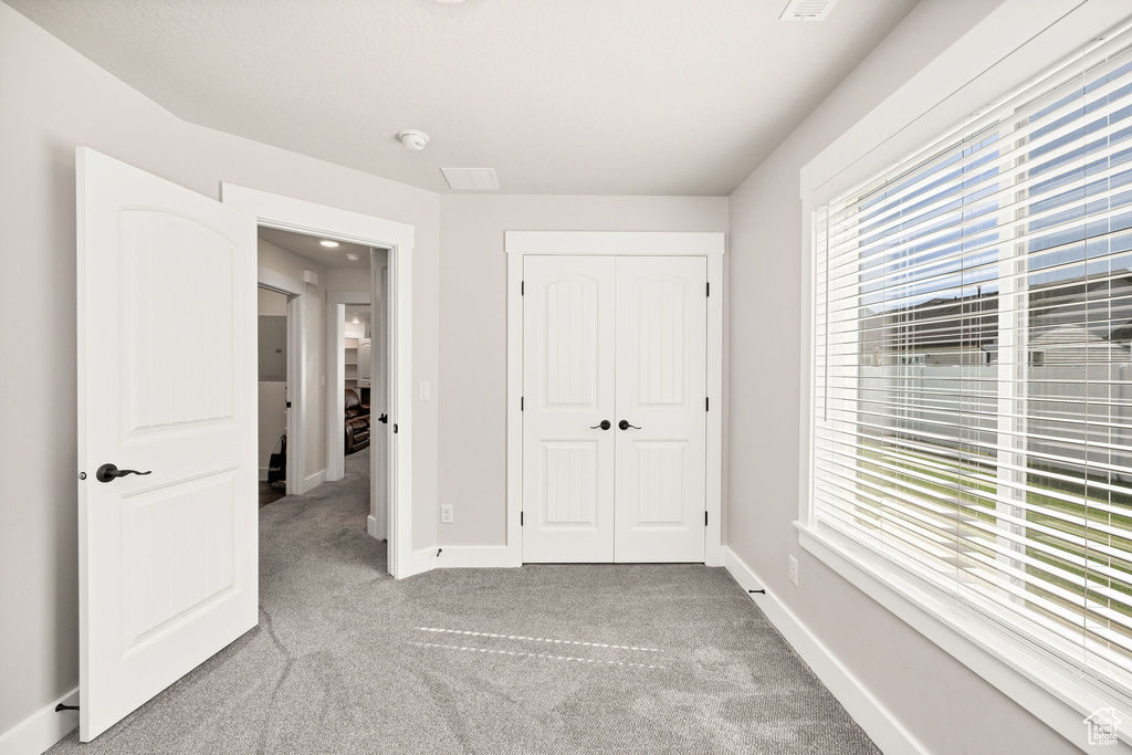 Unfurnished bedroom featuring light colored carpet and a closet