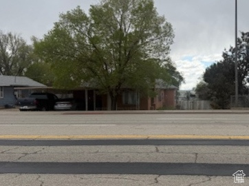 View of asphalt road featuring street lights