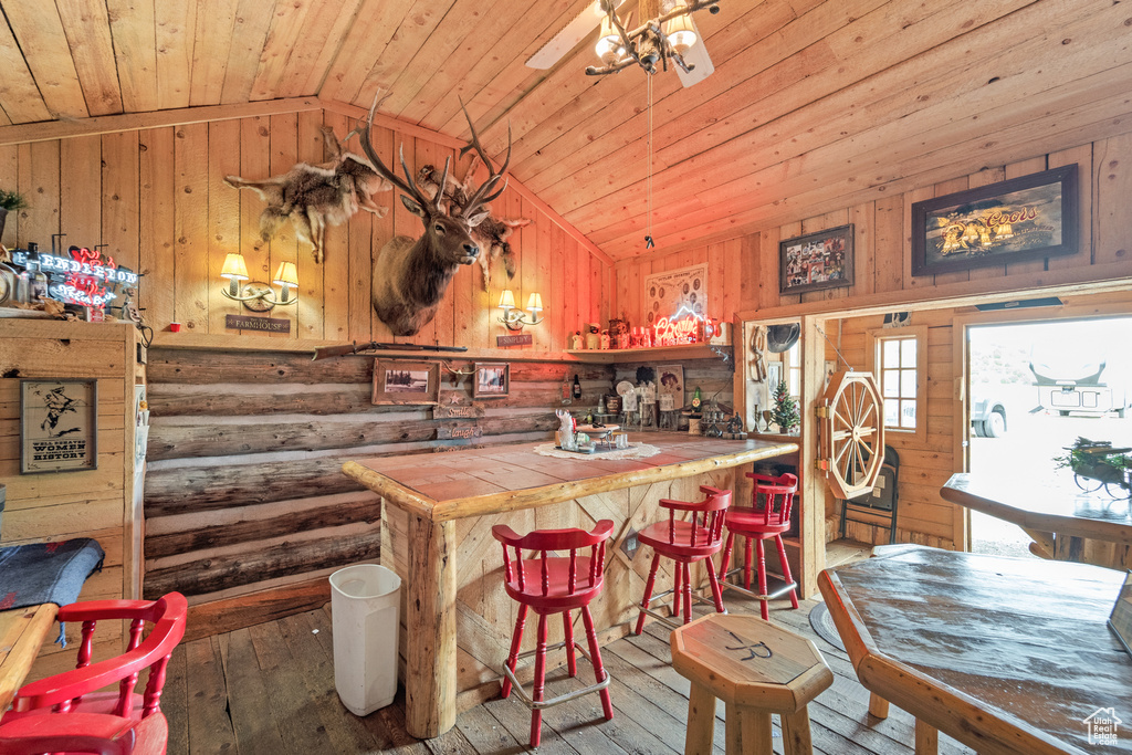 Kitchen featuring tile counters, wooden ceiling, hardwood / wood-style flooring, lofted ceiling, and wood walls