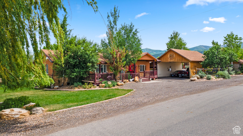 View of front of property featuring dirt driveway, a front lawn, and a mountain view