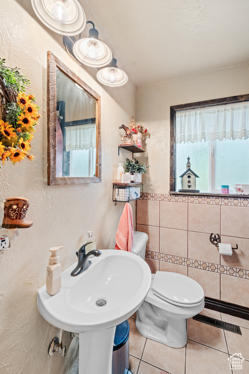 Half bathroom featuring tile patterned flooring and a textured wall