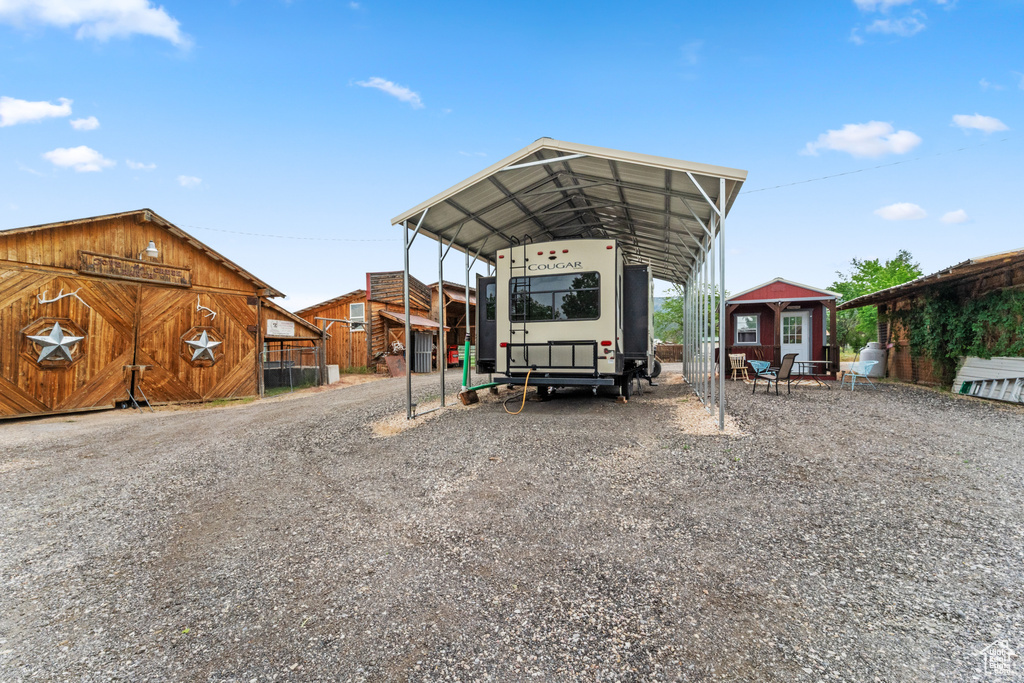 View of parking featuring a carport and gravel driveway