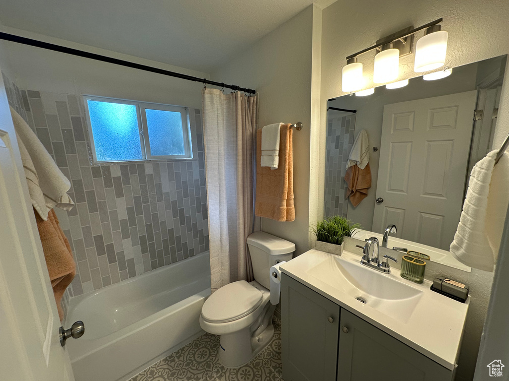 Full bathroom featuring vanity, shower / bath combo, and tile patterned flooring